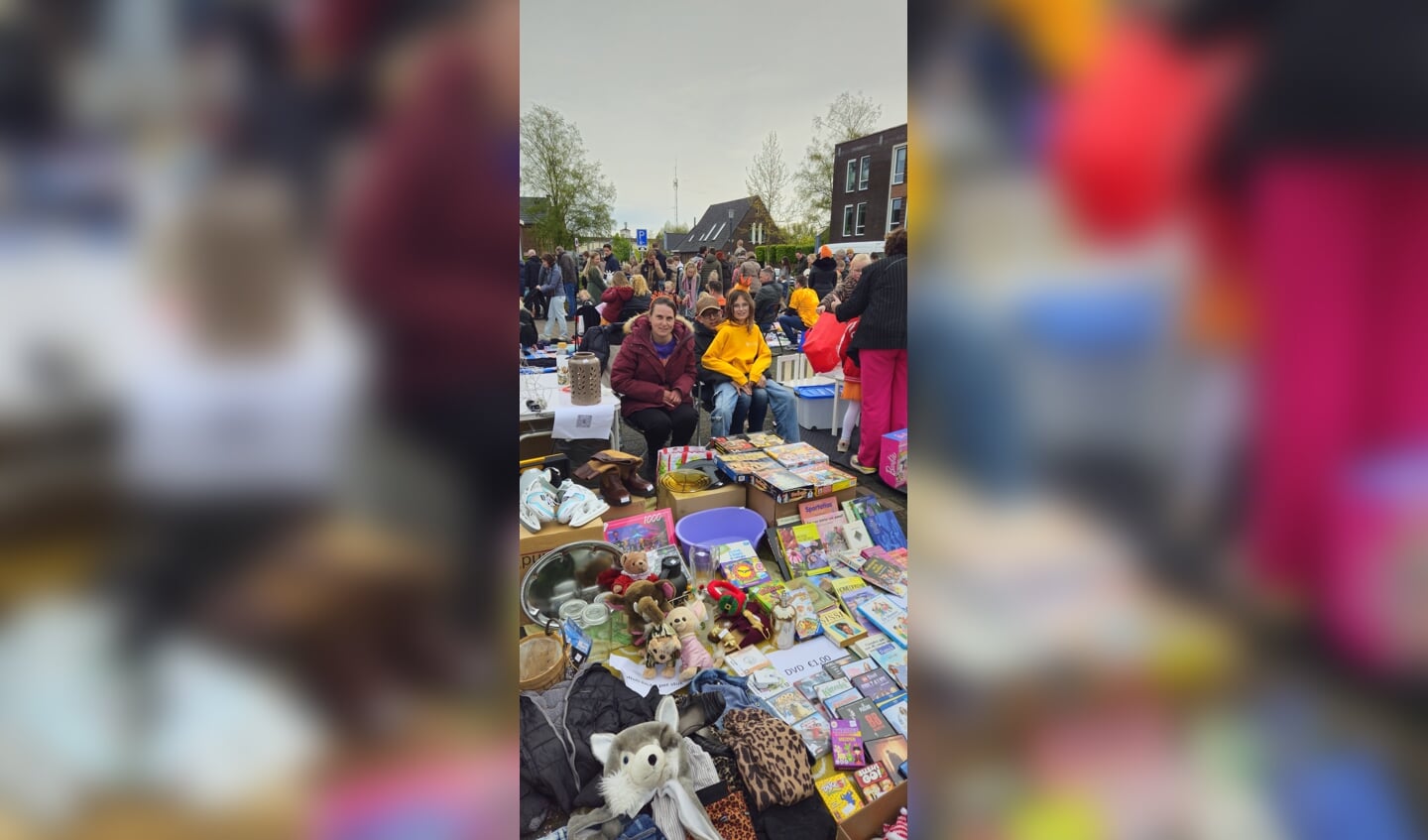 Jolie Klaassen in het oranje verkoopt haar spulletjes op de rommelmarkt tijdens Koningsdag