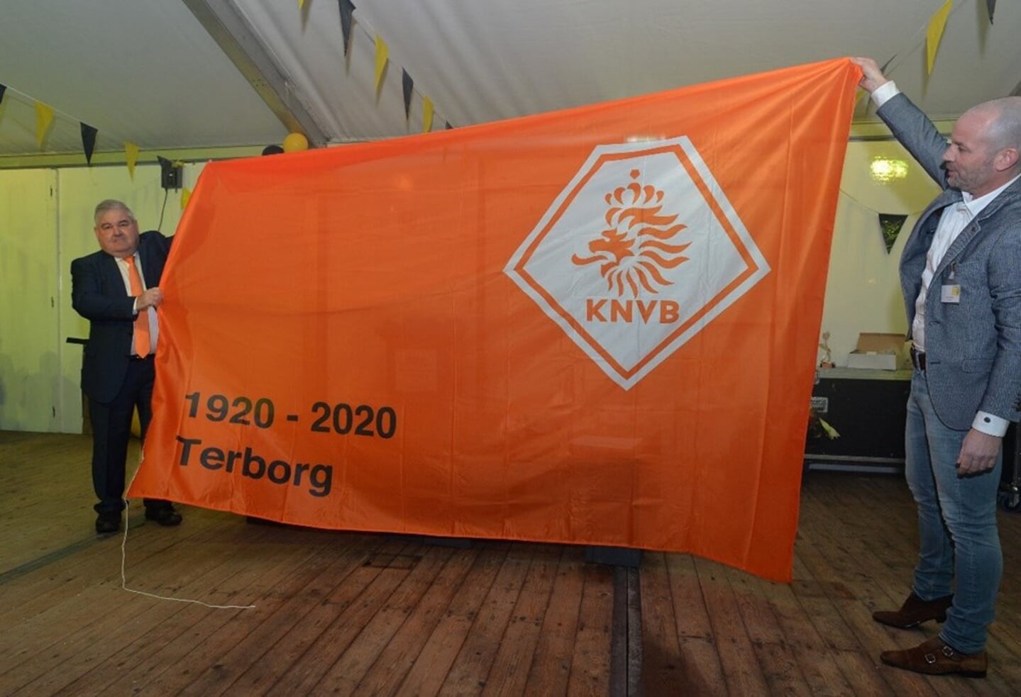 KNVB-ambassadeur Gerard van Balveren en Terborg-voorzitter Marc Neijland tonen de KNVB-vlag bij het 100-jarig bestaan. Foto: Magerago Foto.