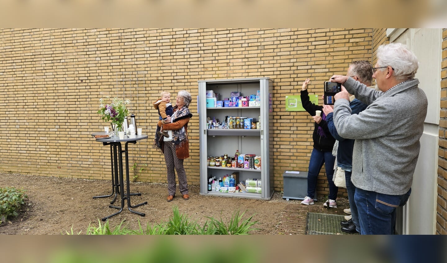 Anja Scholten en kleinzoon Ted openen de eerste voedselkast in Lichtenvoorde aan de Pastoor Sanderstraat. Foto: Dinès Quist 