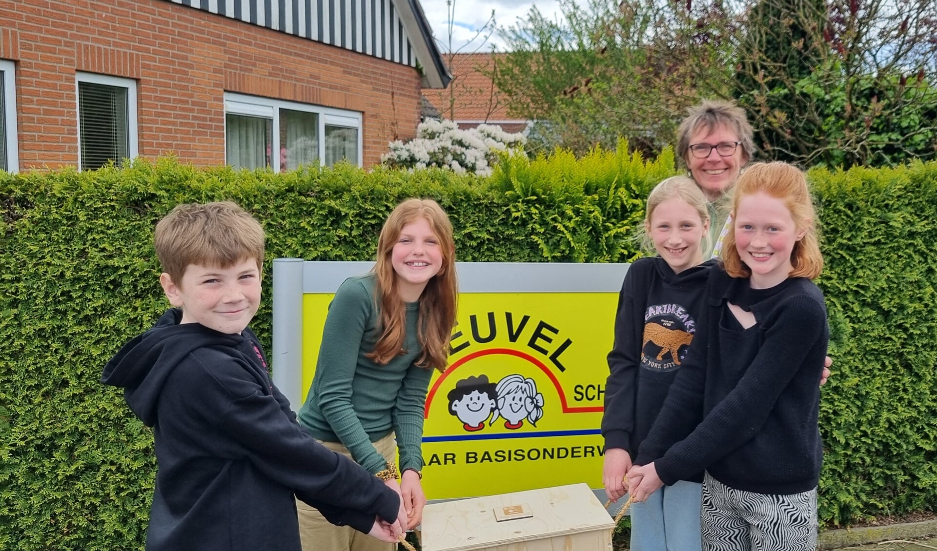 Leerlingen van groep 7 van de J.W. Heuvelschool uit Borculo krijgen de kist overhandigd van projectleider Jeannet Brouwer (staande rechts achter). Foto: Rob Weeber