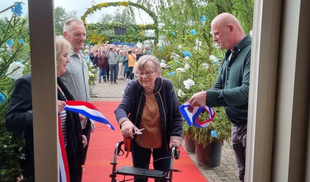 Oud-eigenaar van Café Halfweg Annie Groot-Zevert knipt het lint door en opent daarmee officieel het nieuwe buurthuis Halfweg. Foto: Rob Weeber