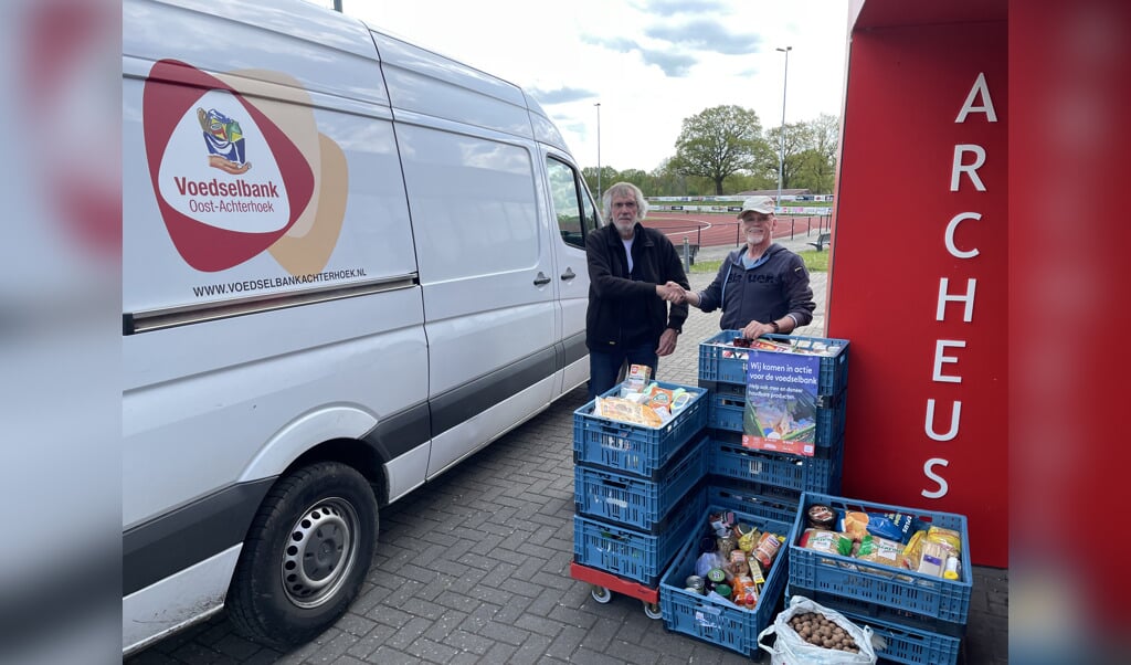 Henk Kok van de Voedselbank Oost-Achterhoek (links) neemt de levensmiddelen in ontvangst van Archeus-secretaris Jos Pierik. Foto PR