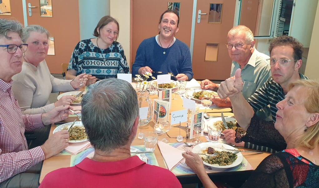 Matthew McPike (in de blauwe trui) zet een veganistische maaltijd op tafel in de Kerkherberg. Foto: PR