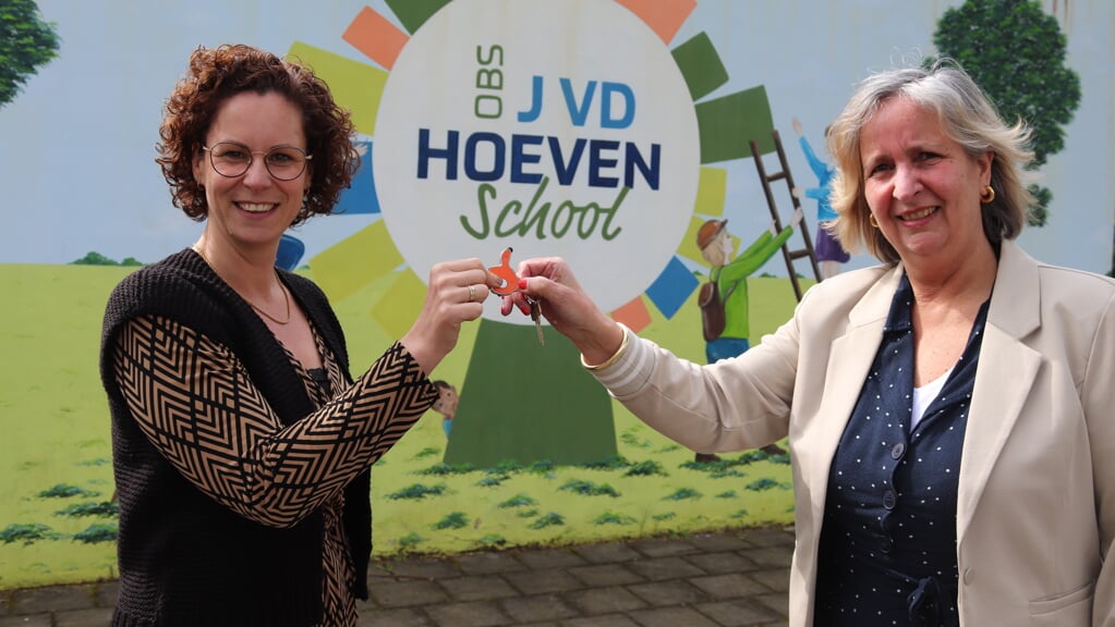 Angela Schreurs (l) neemt de sleutels van de school in ontvangst van Nina Bouwman. Foto: Arjen Dieperink  