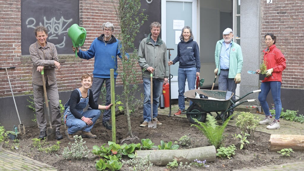 Leden van de Zutphense Werkmakers, buurtbewoners en een vakantieganger bezig met de aanleg van een geveltuintje. Foto: Sander Grootendorst
