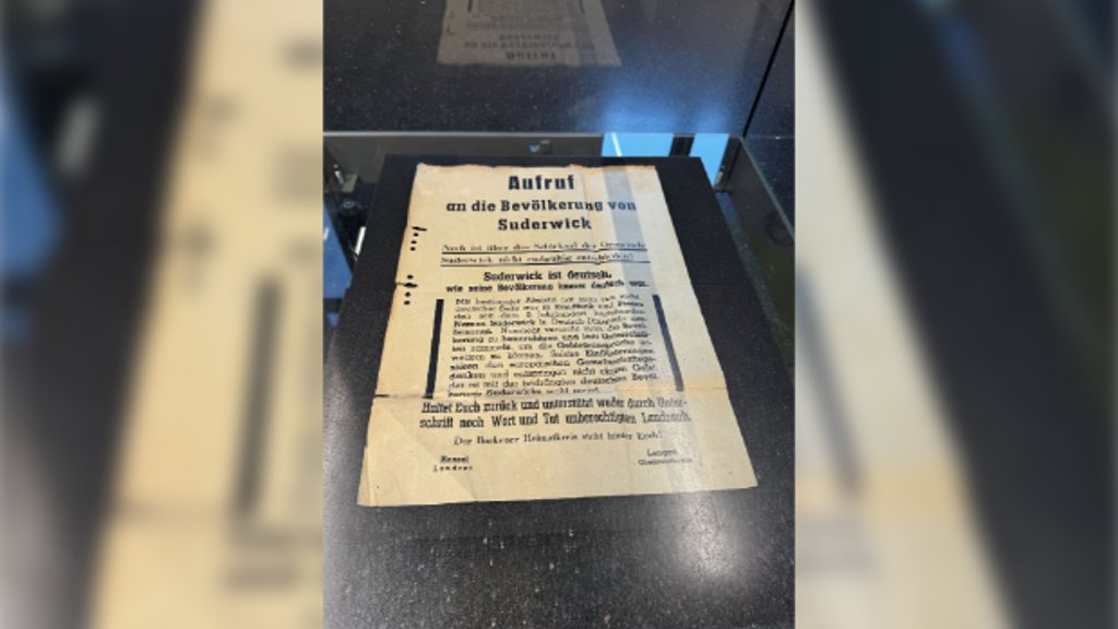 Burgemeester Anton Stapelkamp van Aalten maakte deze foto van een plakkaat waarop inwoners protesteren tegen de annexatie van Suderwick-West. Het plakkaat hoort bij een kleine expositie, onderdeel van het project.