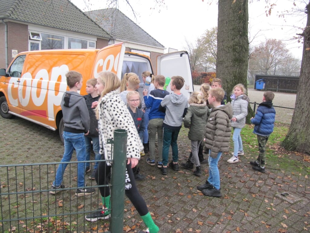 De kinderen mochten helpen het Coop-busje vol lege flessen te stoppen.. Foto: PR
