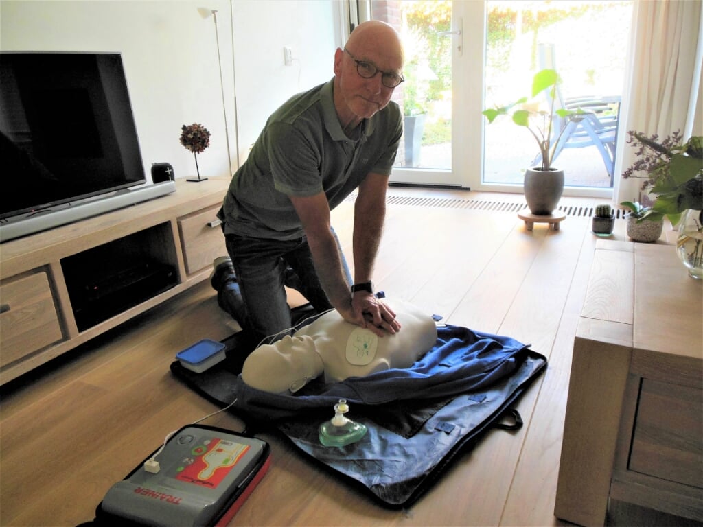 Joop van Berkel demonstreert in zijn huiskamer een AED. “Snel gebruik van dit apparaat verhoogt de overlevingskans na een hartstilstand aanzienlijk.”  Foto: Eric Klop                  