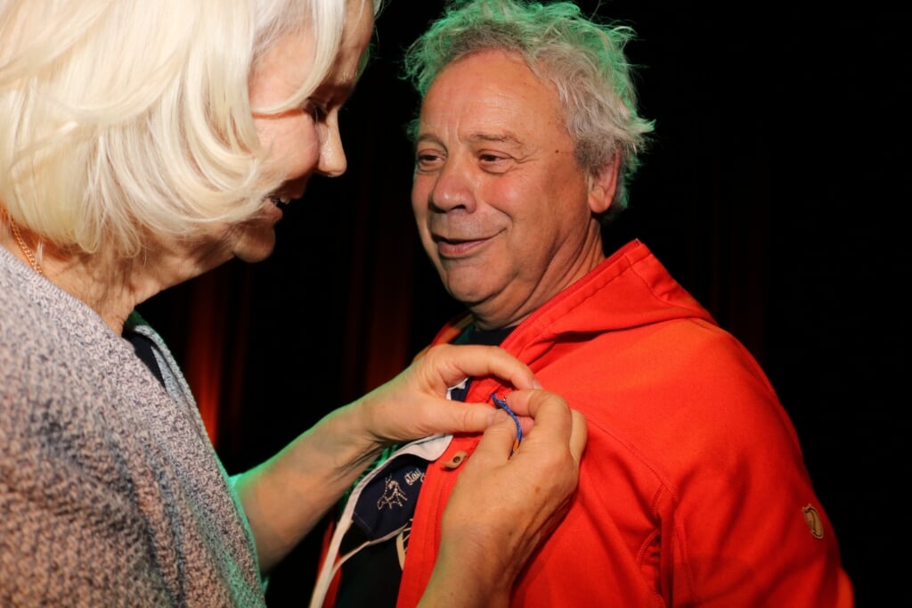 Joost Carlier krijgt de versierselen opgespeld door zijn vrouw. Foto: Arjen Dieperink