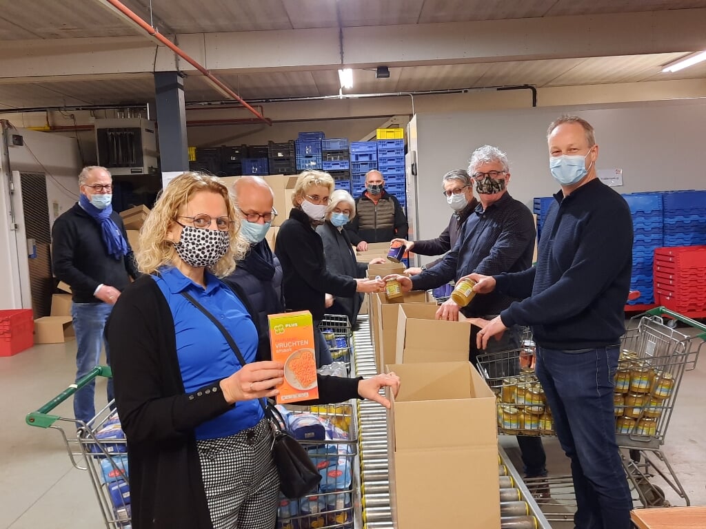 Leden van Rotaryclub Achterhoek Oost pakken extra voedselpakketten in bij de Voedselbank in Lichtenvoorde. Foto: Kyra Broshuis