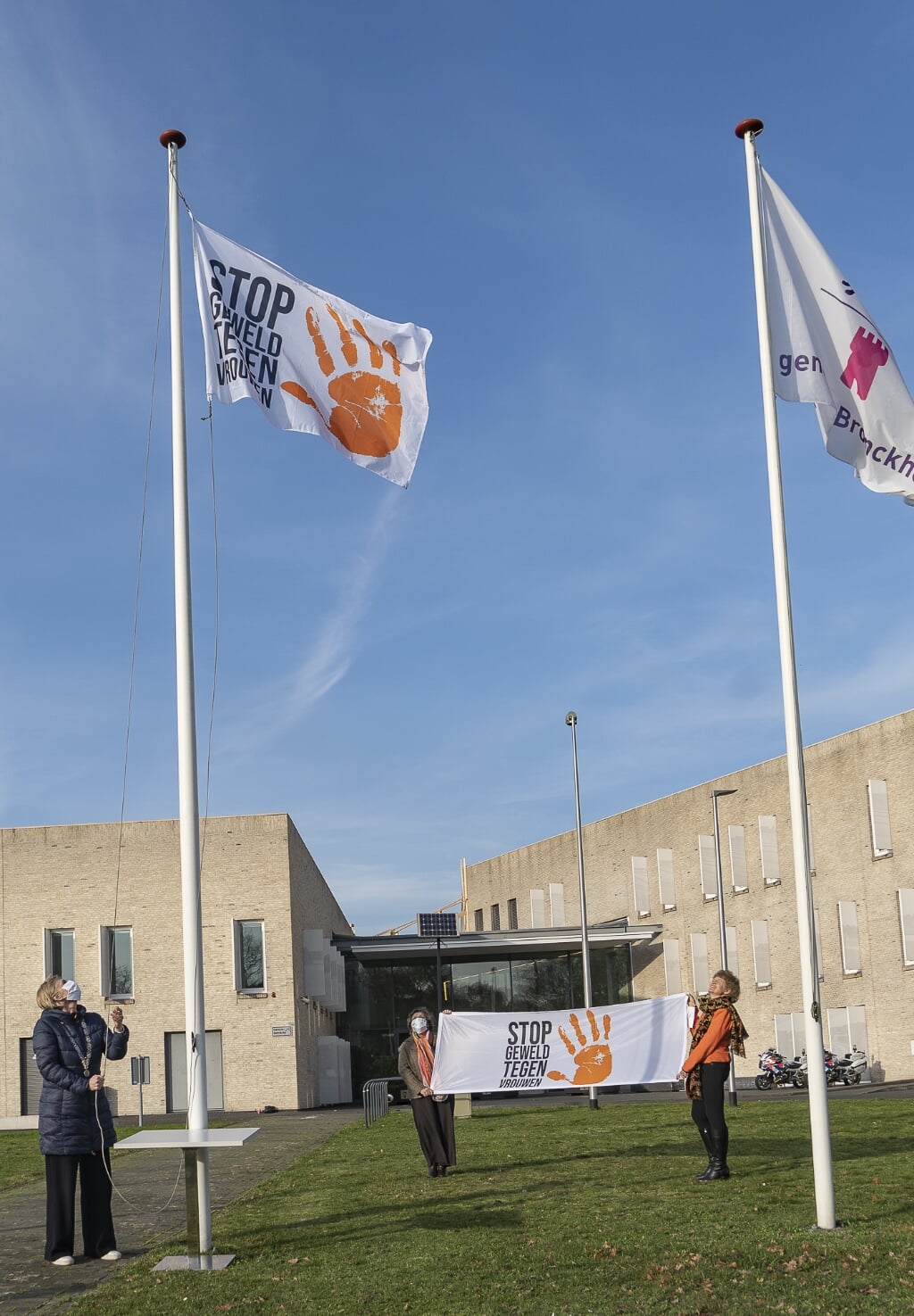 Burgemeester Besselink hijst de ‘stop geweld tegen vrouwen’-vlag bij het gemeentehuis van Bronckhorst. Foto: F.C. Meijer