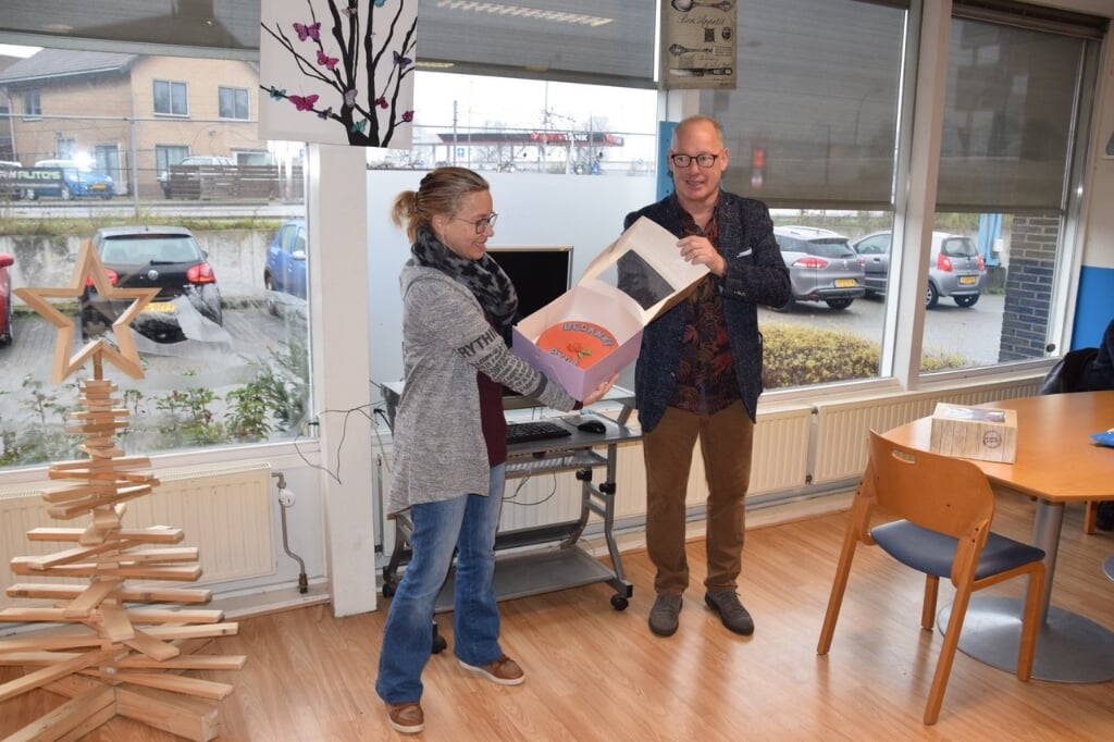 Frans Manders van de PvdA fractie Zutphen reikt de taart uit aan Mirjam die hem namens alle vrijwilligers in ontvangst nam. Foto: PR