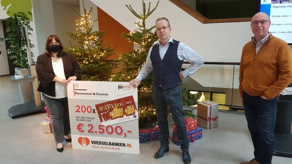 Gijs Ramerman (m) en André Onnink van Ramerman & Onnink overhandigen wethouder Elvira Schepers een cheque van 2.500 euro voor de voedselbank. Schepers: “Geweldig, daar is men vast erg blij mee.” Foto: Han van de Laar