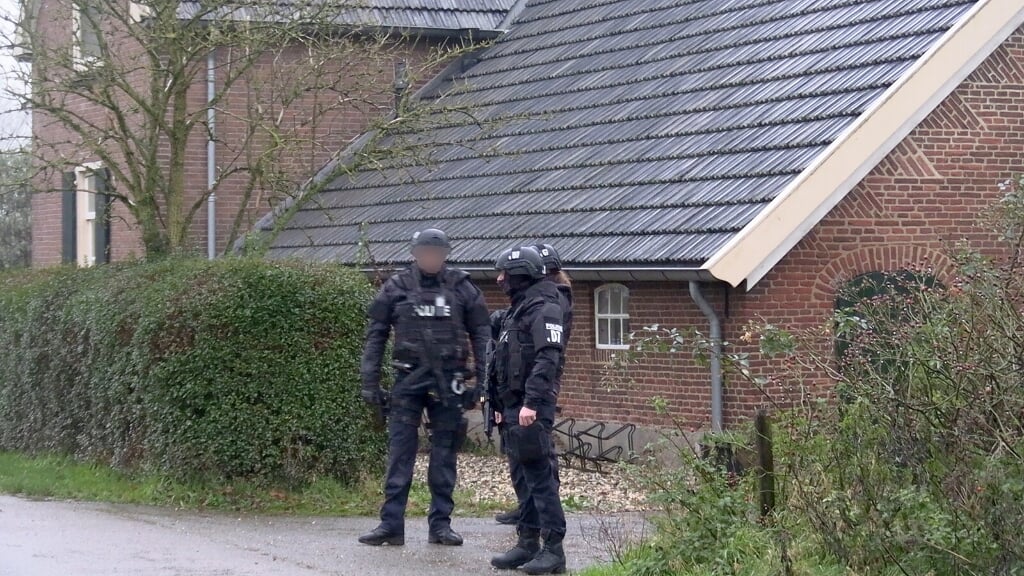 Na de inval door de politie aan de Dollemansstraat in Toldijk werd de locatie bewaakt door zwaarbewapende agenten. Archieffoto: News United / 112 Achterhoek-nieuws