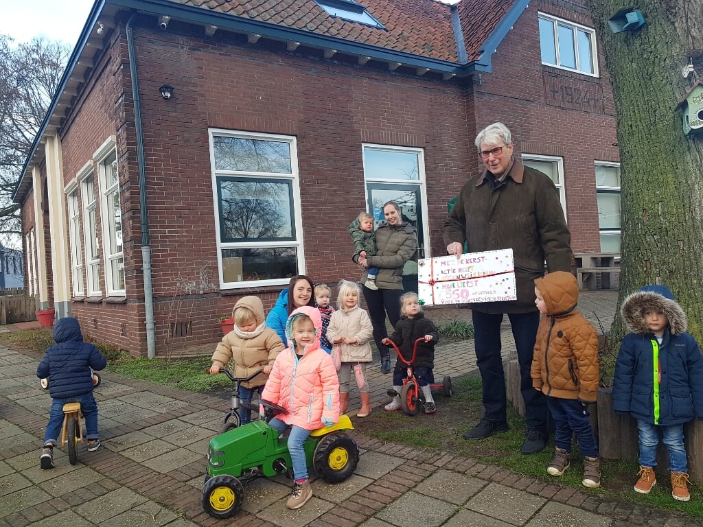 De kinderen van Eigenwijsjerijk, samen met pedagogisch medewerkers Melanie en Ilse, geven een cheque aan en dhr. Vlam, interim-voorzitter van de Wijktuinen. Foto: Selma Hannink-van Ommen