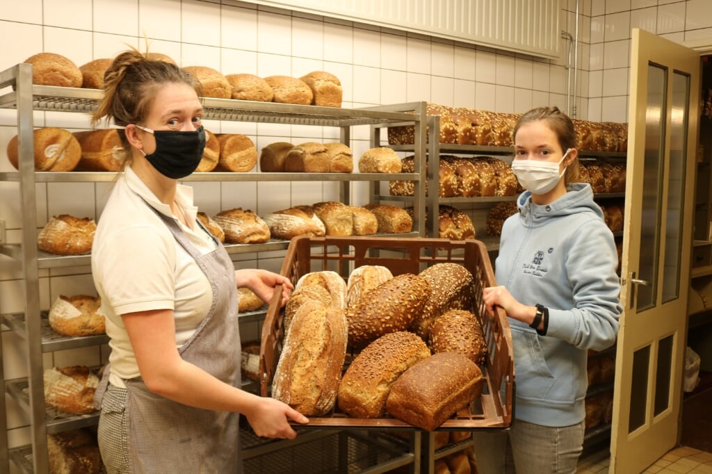 Terwijl Anna (l) en Sara (r) druk in de bakkerij zijn, is hun vader Dick ten Broeke in de winkel het brood aan het verkopen. Foto: Arjen Dieperink