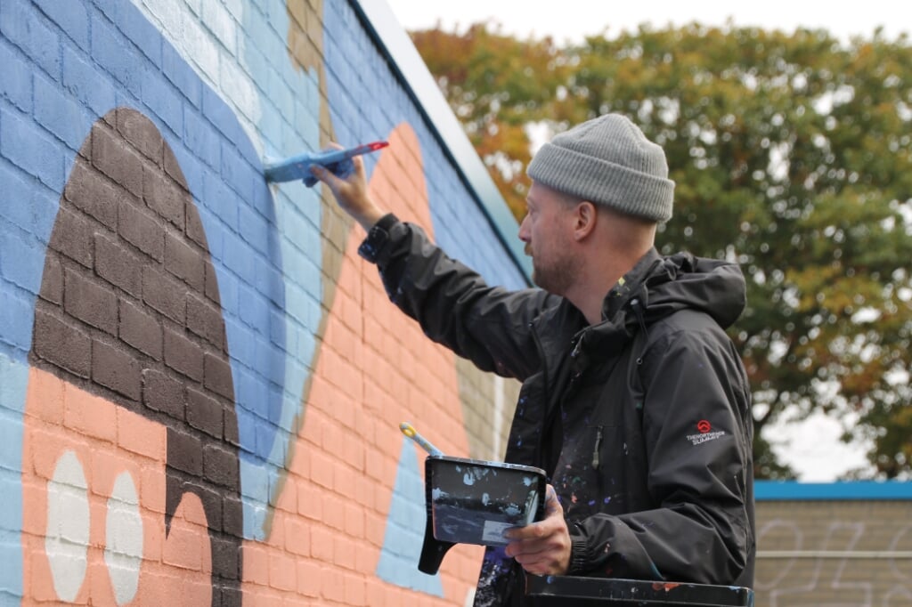 Levi Jacobs aan het werk met zijn muurschildering. Foto: Annekée Cuppers