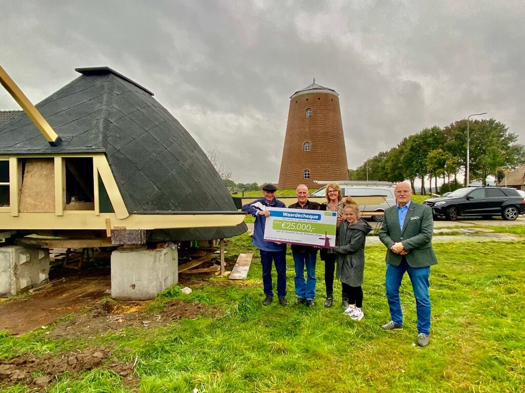 De vrijwilligers van de Braamtse Molen zijn blij met de cheque van 25.000 euro, overhandigd door wethouder Jan van Halteren. Foto: PR