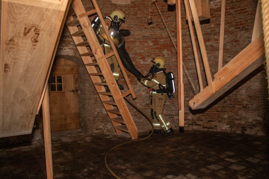 Brandweervrijwilligers brengen via smalle trappen een ‘slachtoffer’ van de hoogste zolder van de molen naar beneden. Foto: Liesbeth Spaansen