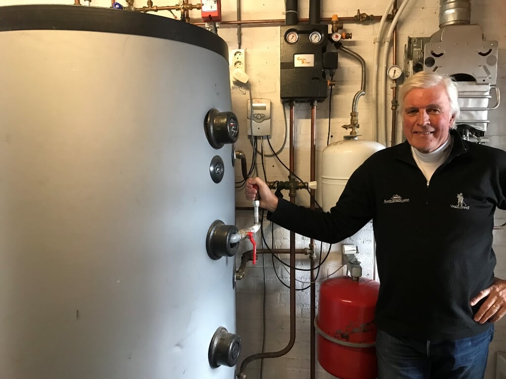 Martien Pater bij zijn voorraadvat voor 800 liter leidingwater dat met zonnecollectoren wordt verwarmd. Foto: eigen foto