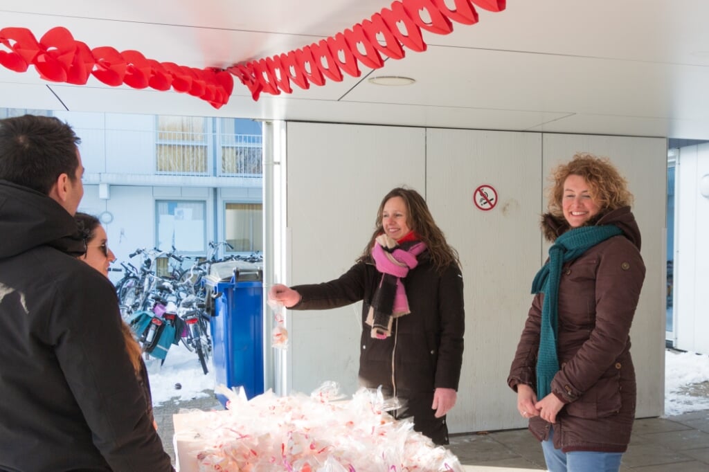 Andrea (links) en Annelies van Koffiehuis Sparkle delen zakjes hartensnoepjes uit aan bewoners AZC. Foto: Henk Derksen