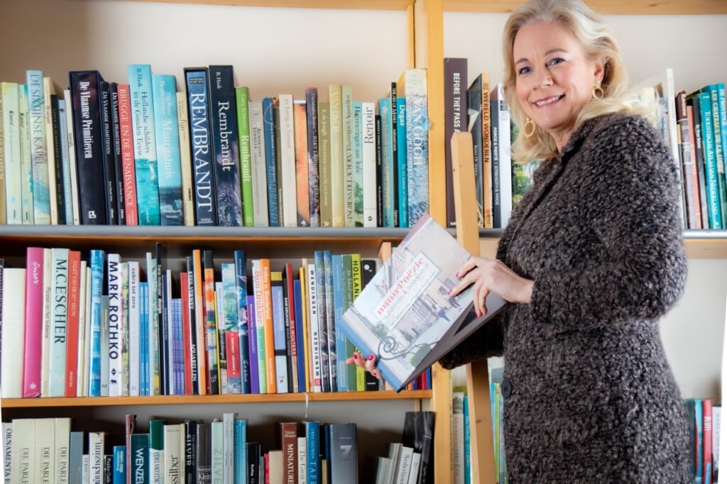 Burgermeester Annemieke Vermeulen zoekt het boek dat ze Jolien Wilmar wil geven. Foto: Petra van Vliet