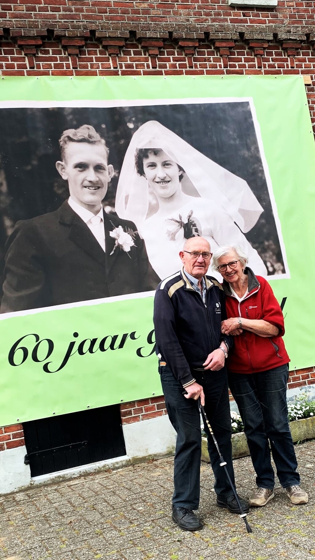 Bennie en Marietje Meekes-Gelinck bij het spandoek voor hun 60-jarig huwelijk. Eigen foto