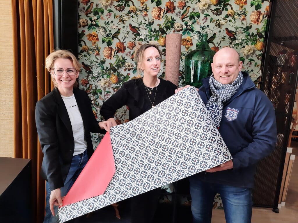 Mechteld Wissink van het GOV, ontwerpster Natasja Scharenborg en Bjorn Snijders van de Grolse Wanten Sociëteit met het Grolse Want-inpakpapier. Foto: Kyra Broshuis