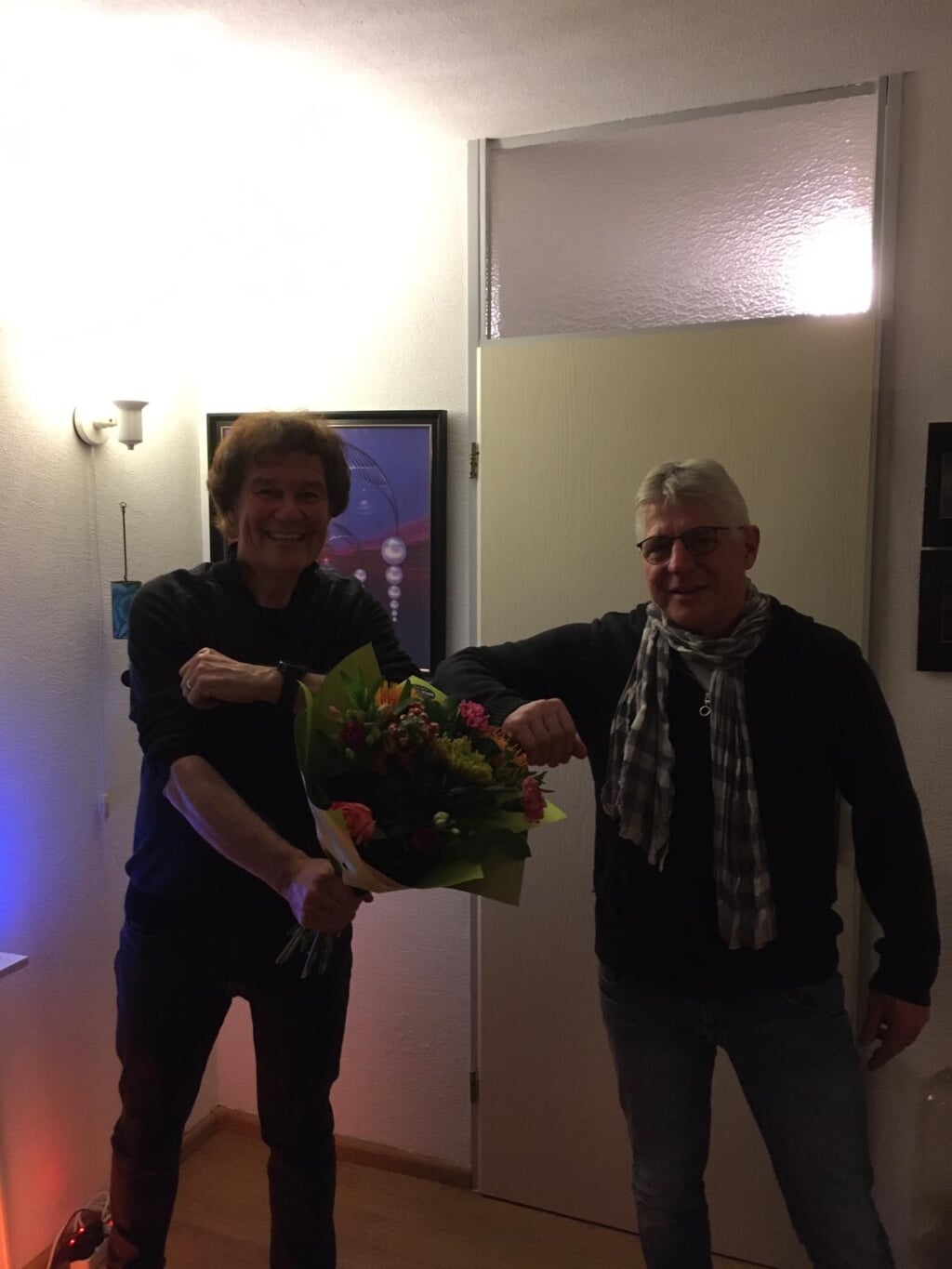 Theo Wierdsma (l) ontving uit handen van Jan Nijenhuis een mooie bos bloemen en een horloge. Foto: PR