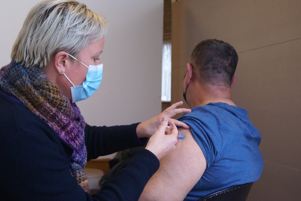 Ingrid Becker zet het vaccin AstraZeneca bij een patiënt. Foto: Eva Schipper
