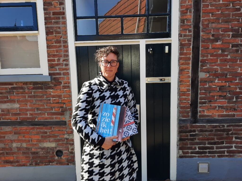 Linda Commandeur met haar nieuwste boek. Eén exemplaar is alvast verpakt in het nieuwe Grolse Wanten-inpakpier. Foto: Kyra Broshuis