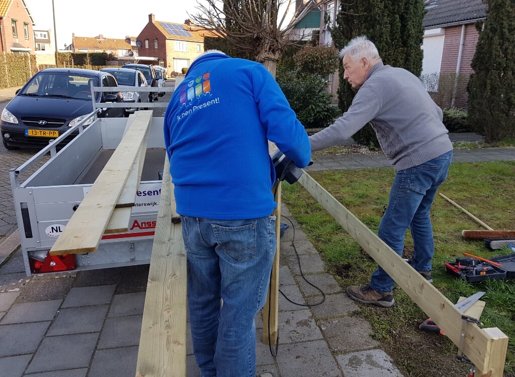 Vrijwilligers Henk en Gerrit maken een hekje om een van de tuinen van Sociaal Groen. Foto: Present Winterswijk