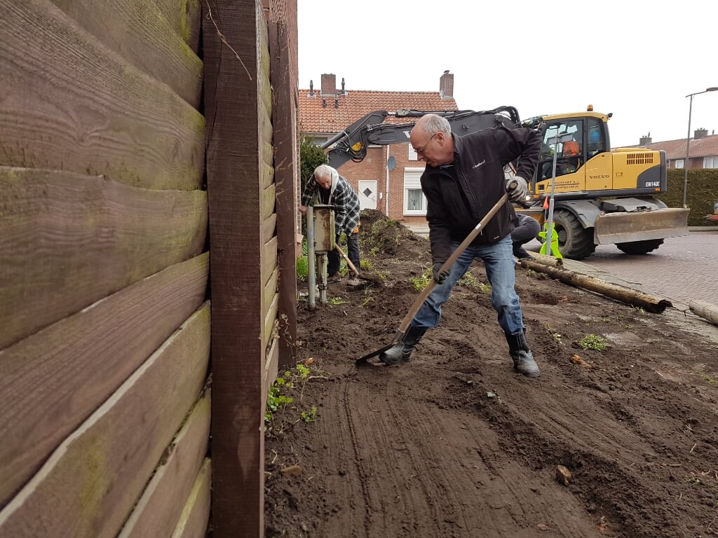 Vrijwilligers van Present en Loonwerkersbedrijf Huiskamp maken een van de tuinen schoon
