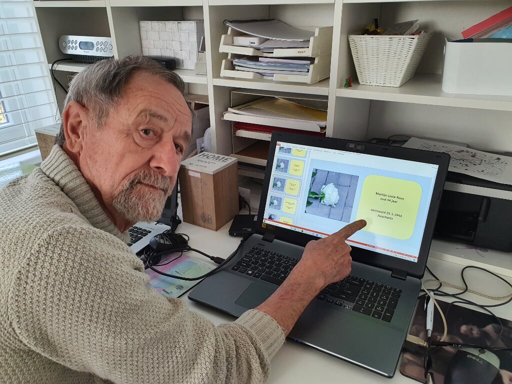 Henk Gerrits achter zijn laptop, wijzend naar een van de namen 'zonder gezicht'.