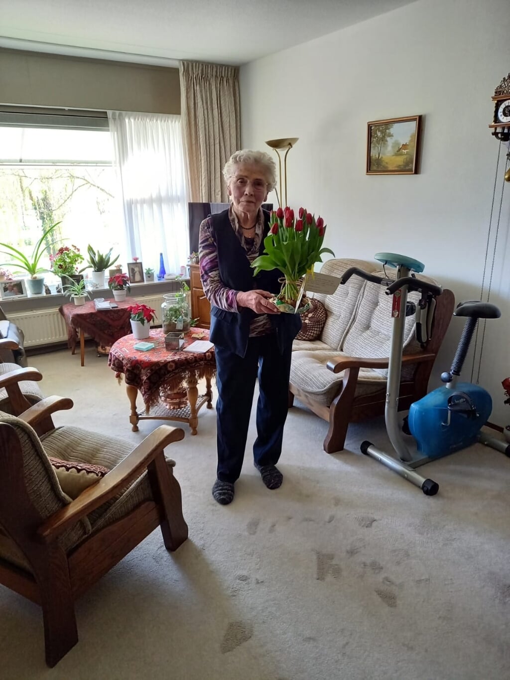 Ook mevrouw Dinie Wunderink-Harenberg die al 60 jaar lid is, kreeg een schoof tulpen. Foto: Janny Lenselink