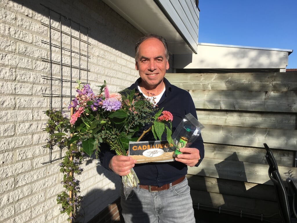 Paul Mokkink neemt bloemen en dinerbon Eetcafé Jansen & Jansen in ontvangst. Foto: PR HLTC Het Elderink