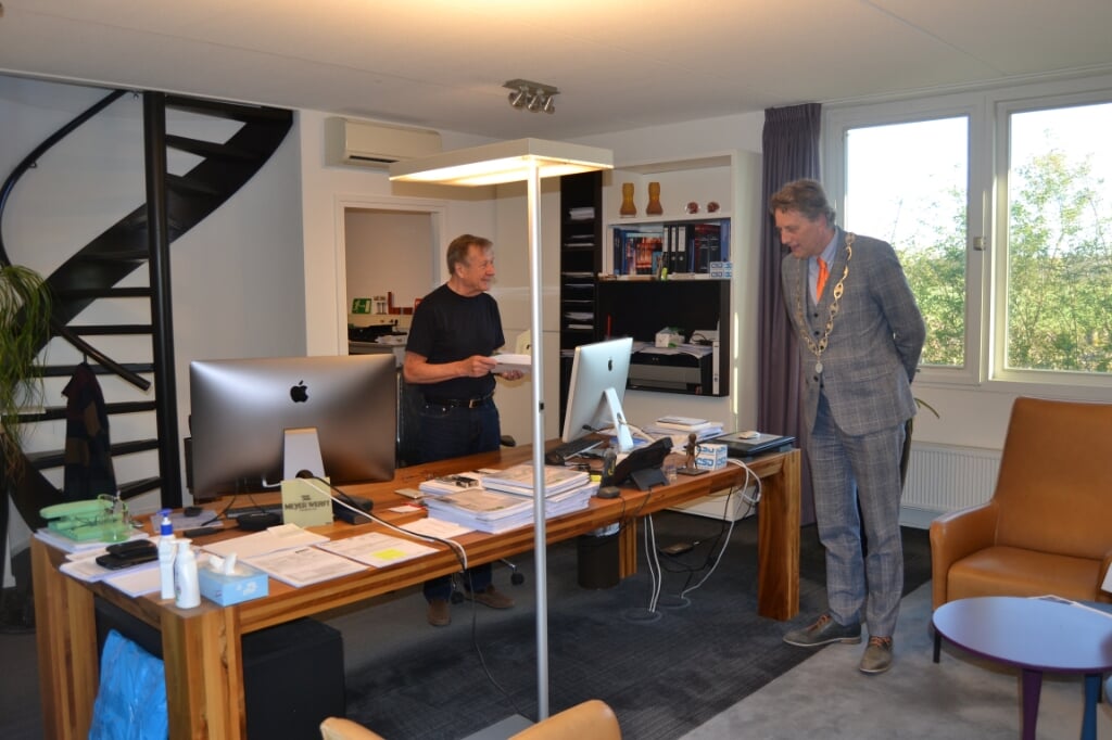 Burgemeester Stapelkamp heeft de mededeling dat 'het de Koning heeft behaagd' overhandigd aan Hans Beele, die om half acht al druk aan het werk was in zijn kantoor. Foto: Karin Stronks