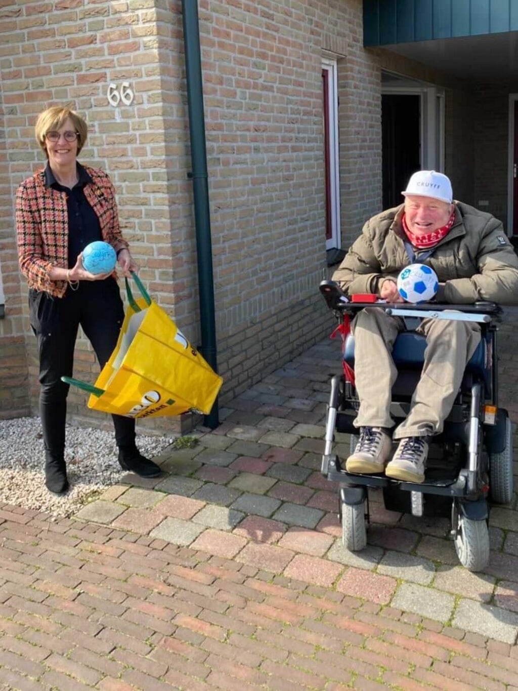 Frank overhandigt Burgemeester Bronsvoort een tas vol ballen.