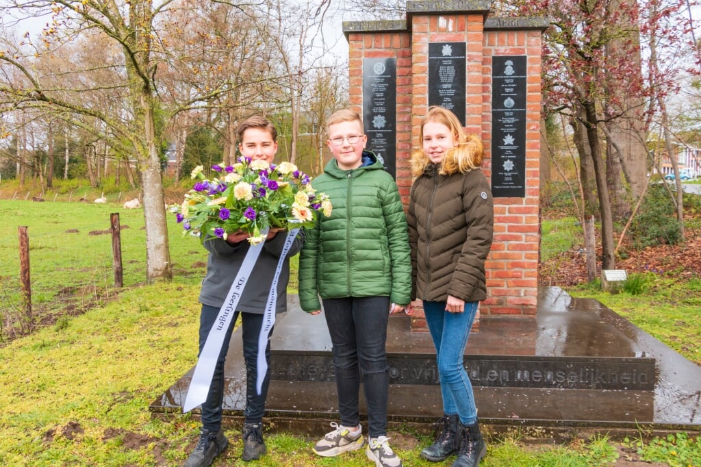 Leerlingen van CBS Arcade met het bloemstuk bij het monument. Foto: Henk Derksen