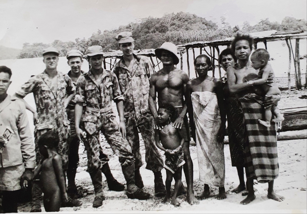 Op de achterzijde van de foto staat; 'Een nacht geslapen bij de Papoeaas in de kampong. Allemaal op een prentje voor we weg gingen.' Foto: archief Antoon te Brake