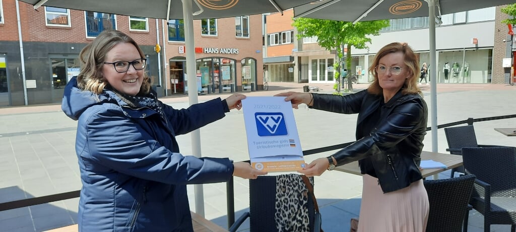 Mirjam Tolkamp (l) van de VVV overhandigt het eerste exemplaar van de nieuwe Toeristische Gids aan wethouder Marieke Frank. Foto: Kyra Broshuis