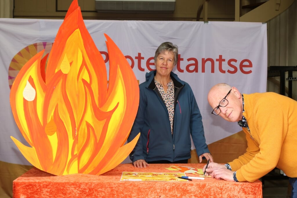 Janny Gerritsen bij de Vlam van Hoop terwijl Sander van Voorst een tekstballon beschrijft. Foto: Arjen Dieperink