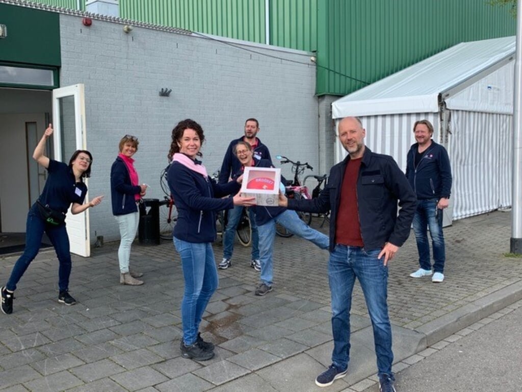 PvdA-fractievoorzitter Jasper Bloem overhandigt de rode taart aan de GGD-medewerkers. Foto: PR