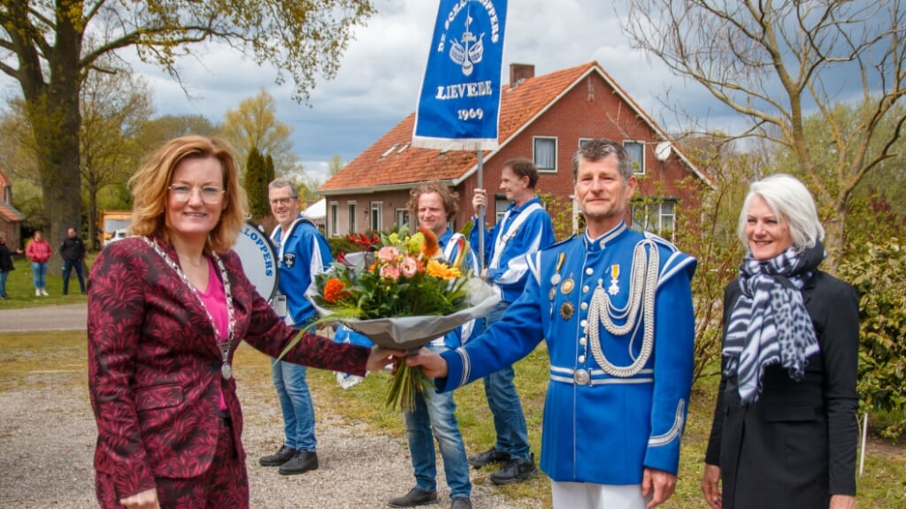 Locoburgemeester Marieke Frank reikt een koninklijke onderscheiding en bloemen uit aan Broddy Krabbenborg. Rechts zijn vrouw, Nardy Krabbenborg. Foto: PR
