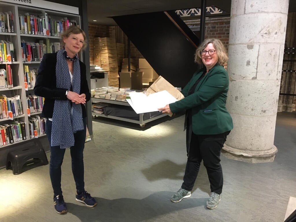 Journalist Alize Hillebrink (l) schonk de bibliotheek symbolisch een ‘leeg boek’ waarin iedereen een wens of herinnering kan schrijven. Foto: PR