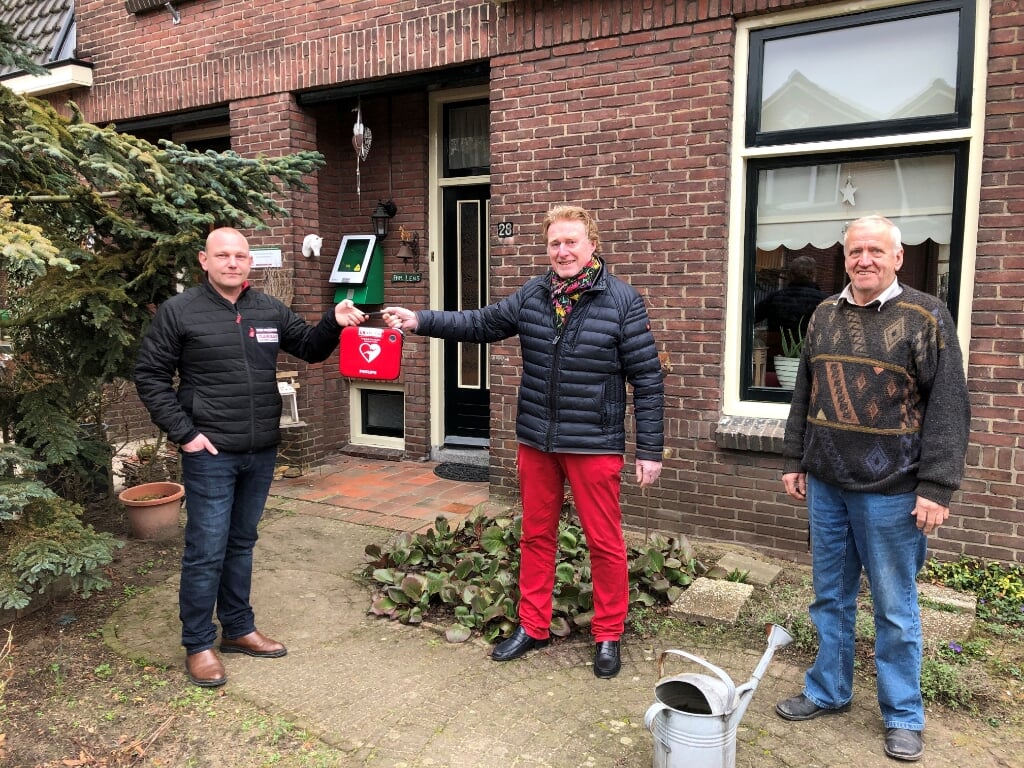 Overhandiging van de buurt-AED in de Kortestraat, van links naar rechts, initiatiefnemer Richard Oberink, Johan G. Esendam, voorzitter Hart4Winterswijk en Johnny Lens waar de AED hangt. Foto: Wim Kos.
