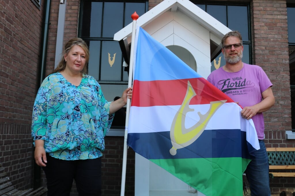Esther en Serge van Dijk staan met de veteranenvlag klaar om de mede-veteranen te verwelkomen. Foto: Arjen Dieperink