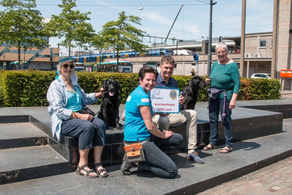 Linda van de Kolk neemt samen met twee van de vrijwillige gastgezinnen van Hulphond Nederland de cheque in ontvangst van Lionslid Paul Bombeld. Foto: Jolien Wilmar