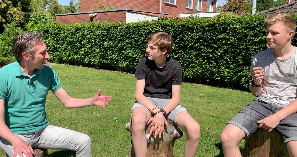 Sander Ris (links) in gesprek met Joran en Janiek (rechts) bij het Dorpshoes in Gelselaar. Foto: PR