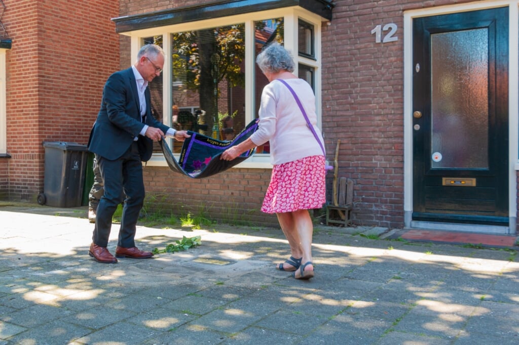 Wim Schipper en Franca Koopman leggen kleed met dichtregels voor de onthulling. Het adres van de familie Heilbronn aan de Rembrandstraat 12. Foto: Henk Derksen  